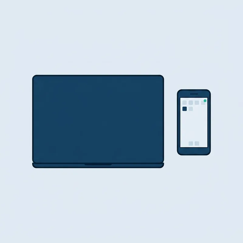 A laptop and a mobile phone lying side by side on a plain desk, seen from above