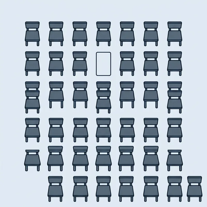 A grid of identical chairs photographed from directly above with one place empty